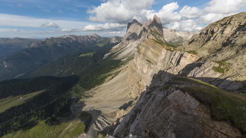 A range of stone mountains seen from the top of one of them and the clouds in the sky are moving quickly