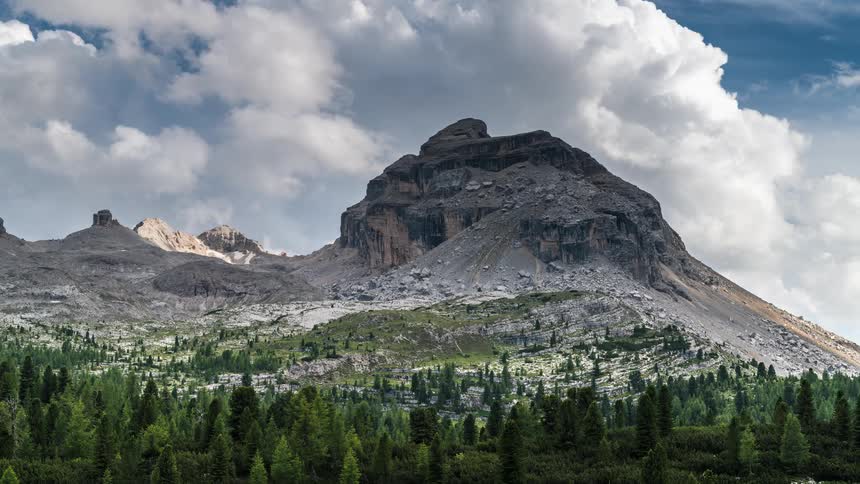 Mountainous landscape with a prominent peak under a partly cloudy sky