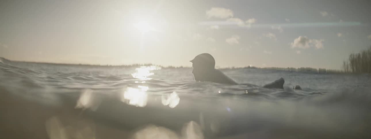 A surfer paddles out in the ocean