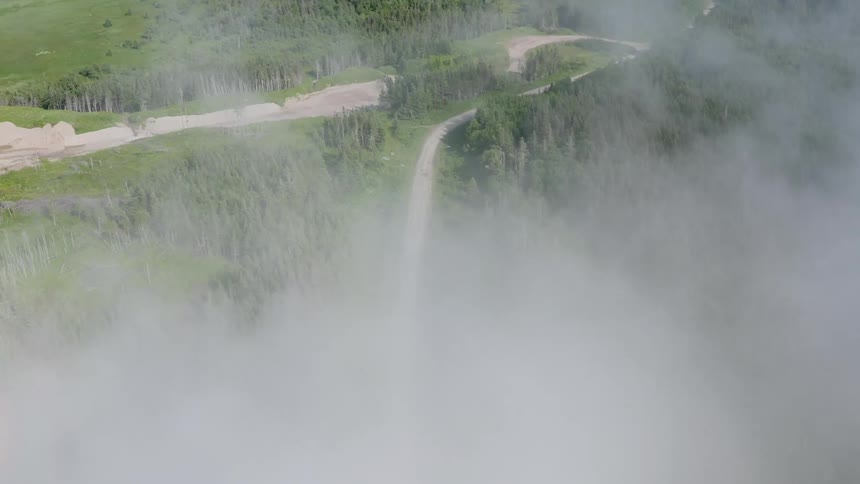 Aerial panorama of a road that winds through hills and forests