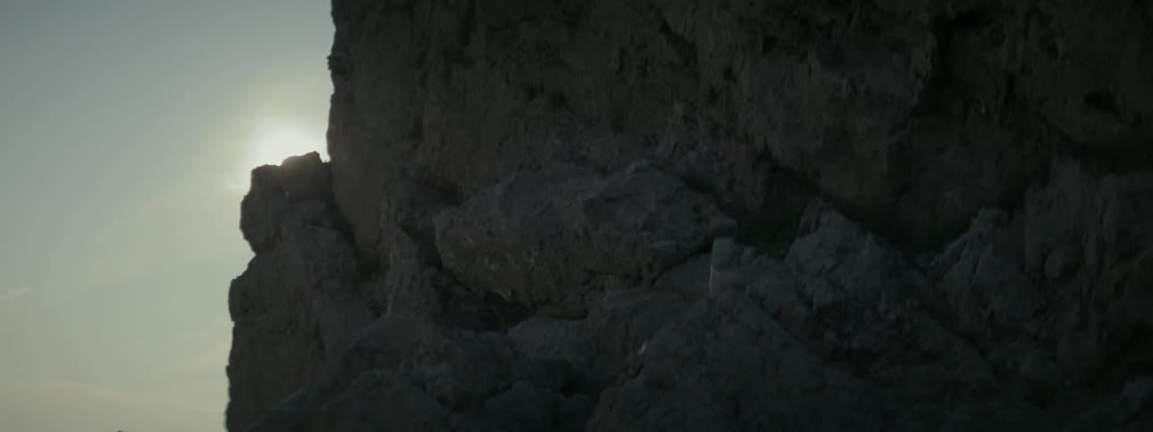 The sun glares behind the mountain