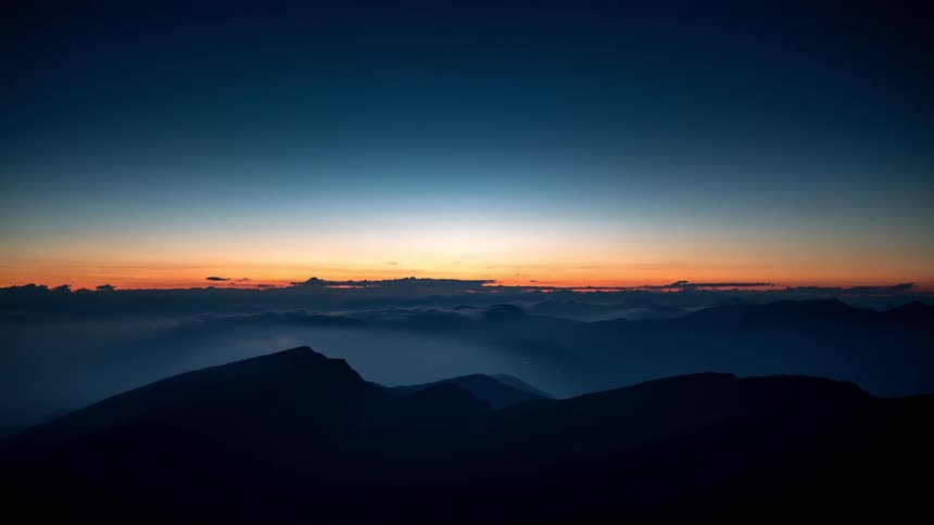 The sky is red at sunset above the mountains