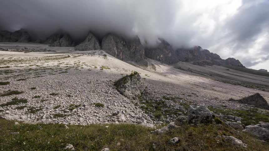 Time lapse of clouds rolling over a rugged mountain landscape