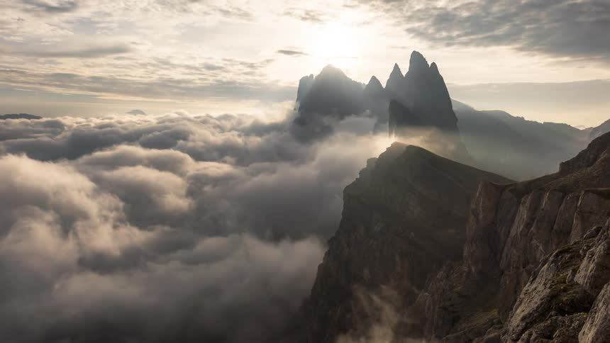 Clouds flow over the peak of the mountain