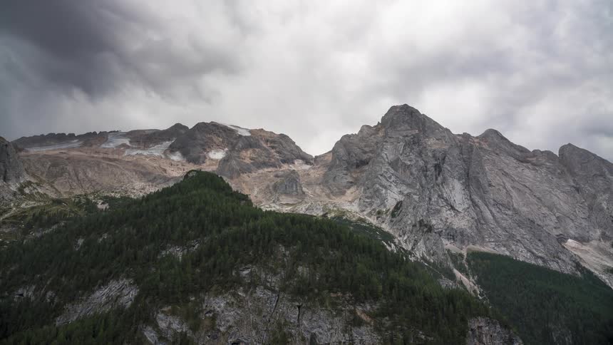Rocky mountains with forests and cloudy clouds