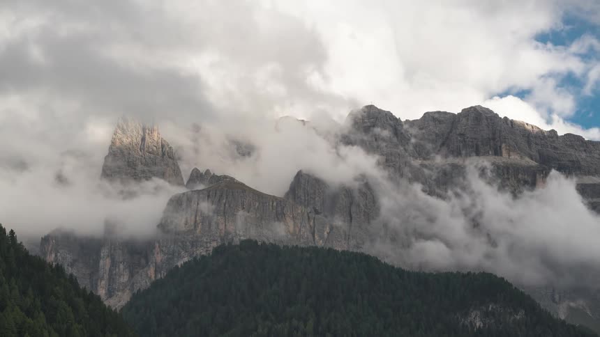 The clouds sit on the peak of the mountain