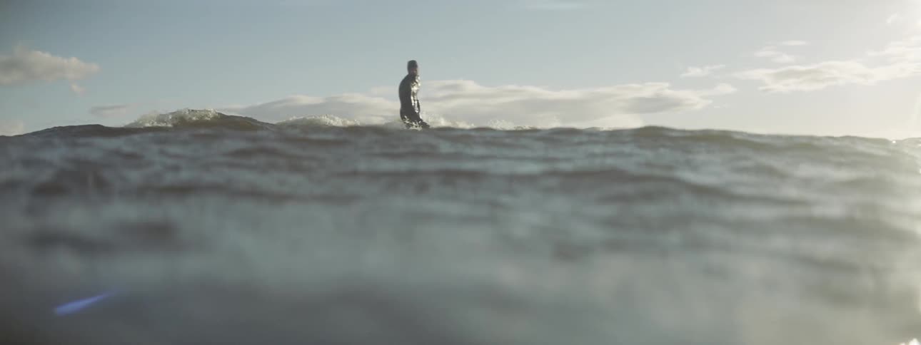 A man is surfing in the water before falling over