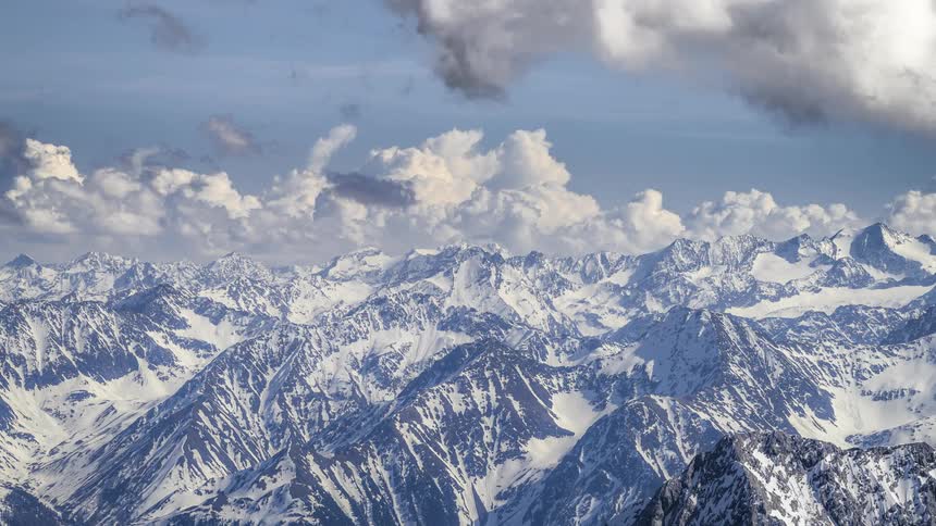 Clouds speed across the sky over an arctic mountain range