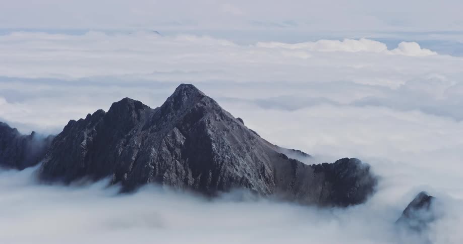 Mountains with rocky peaks in a sea of clouds around