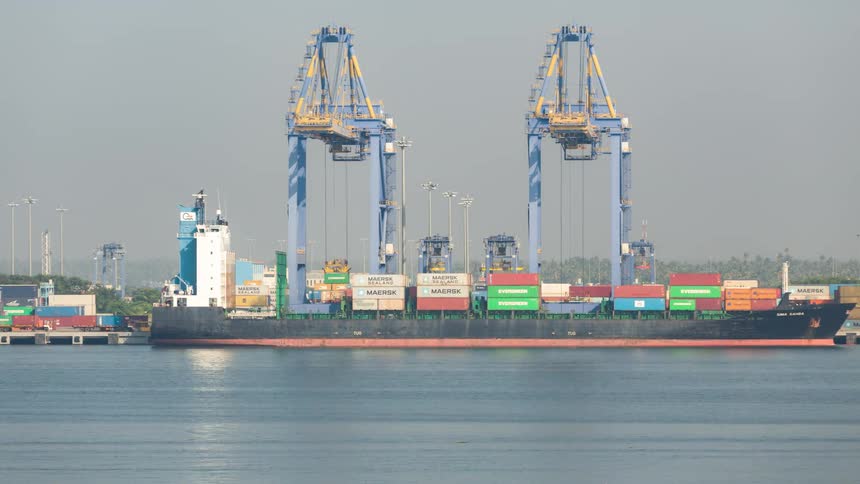 Time lapse of gantry cranes loading a large cargo ship docked at a port