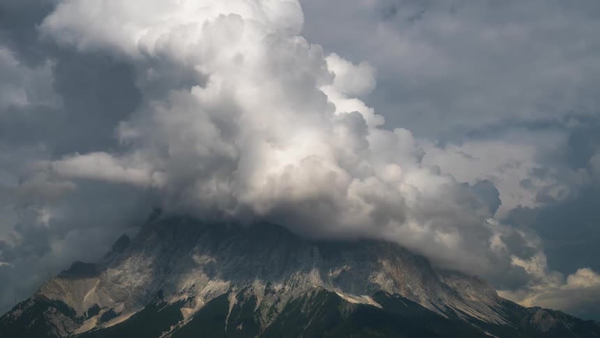 Huge clouds roil over a mountain top