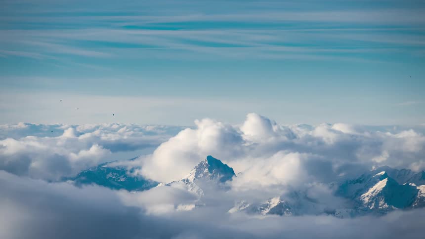 Landscape of mountains covered by snow and clouds passing by