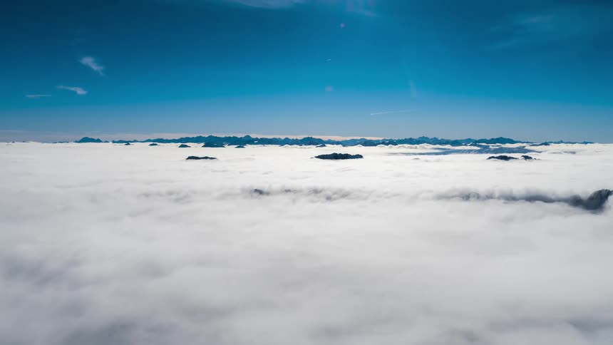 Landscape in a sea of clouds against a blue sky