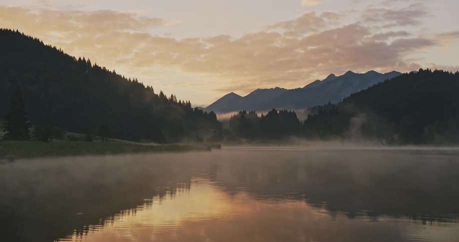 Fog rolls over the lake at sunrise