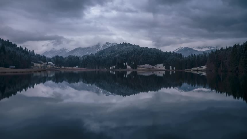 The lake is reflecting the hills and trees