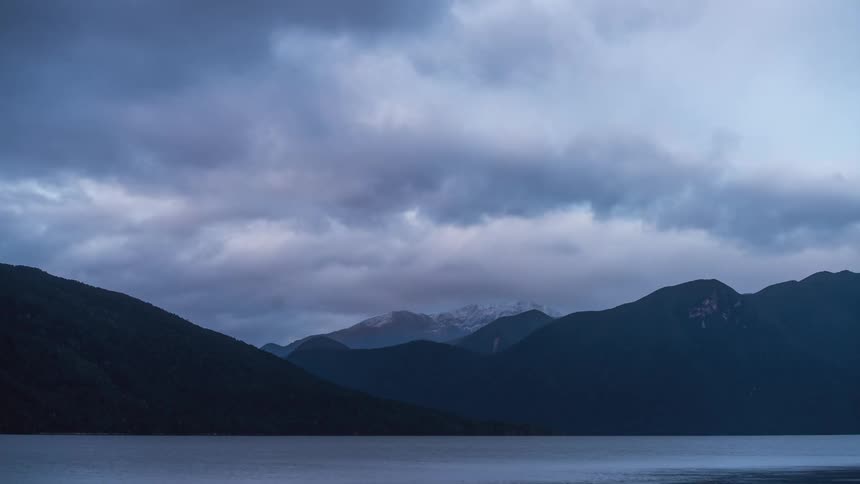 Silhouette of mountains by the sea with the dawning sky on a cloudy day