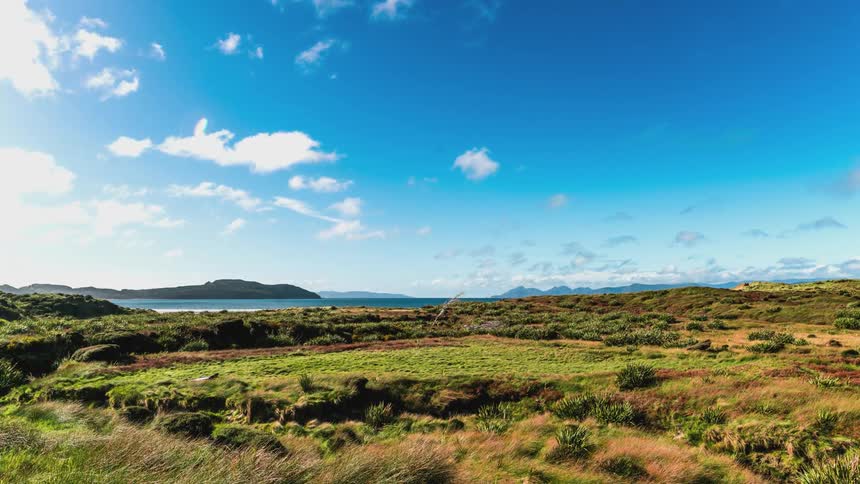 Natural landscape by the sea against a blue sky with clouds