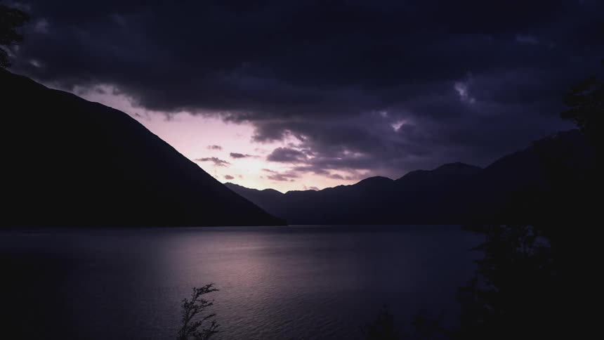 The clouds travel over the lake and mountains