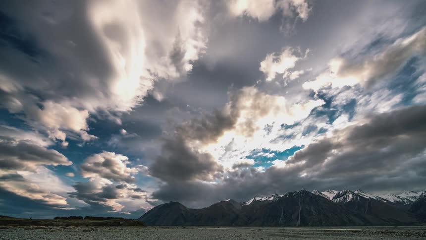 Rows of clouds flow over the mountains
