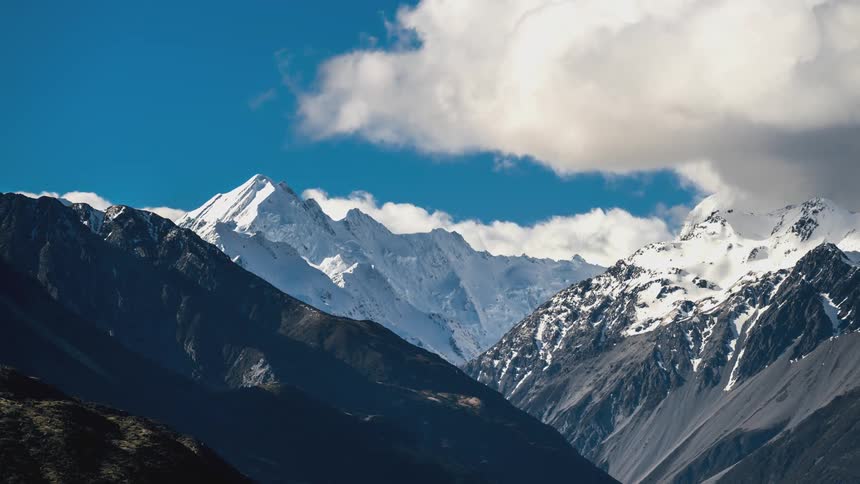 Mountain range with snowcapped peaks illuminated by the sun