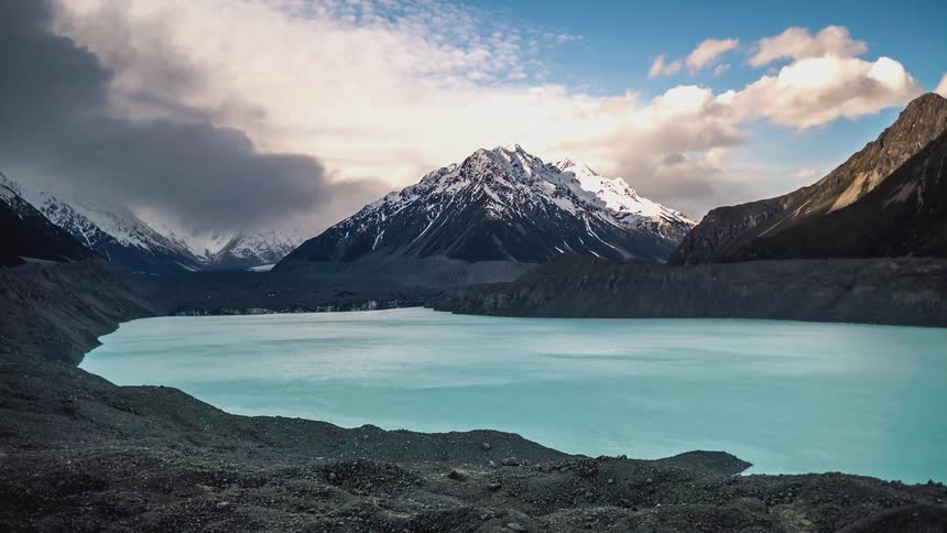 Landscape of a blue lake surrounded by mountains in an early morning