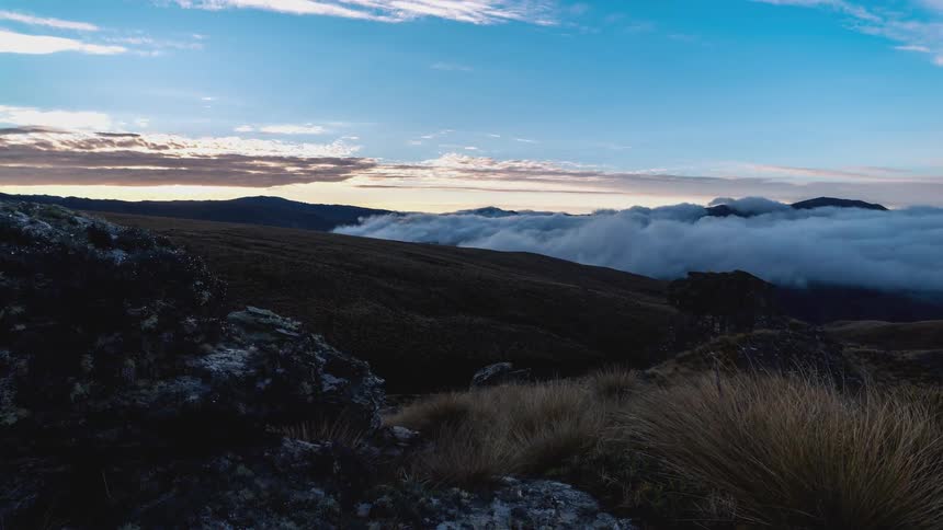 Time lapse of a sunset over mountainous wilderness under a blue sky