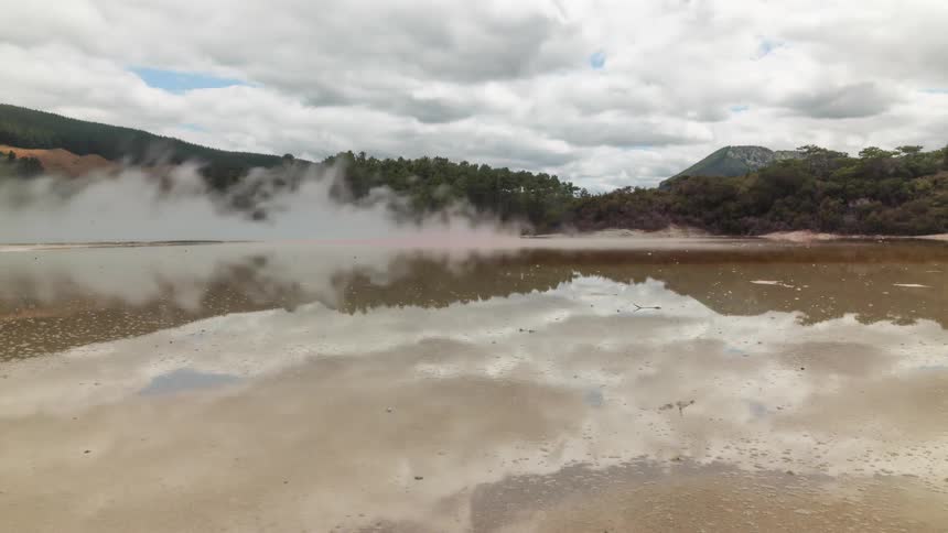 Clouds and fog passing over a forest lake reflected in the water