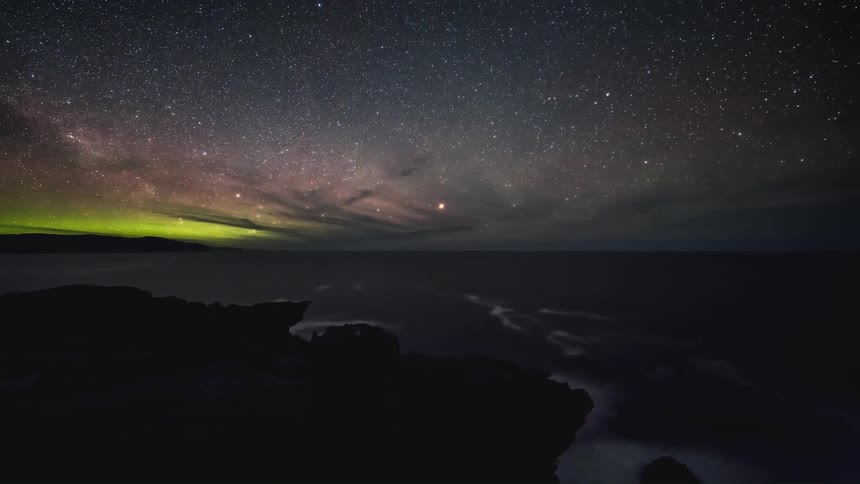 The milky way galaxy appears in the sky as clouds around a mountain