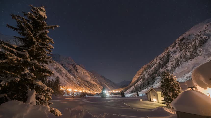 Dusk day over mountains with conifers covered by snow