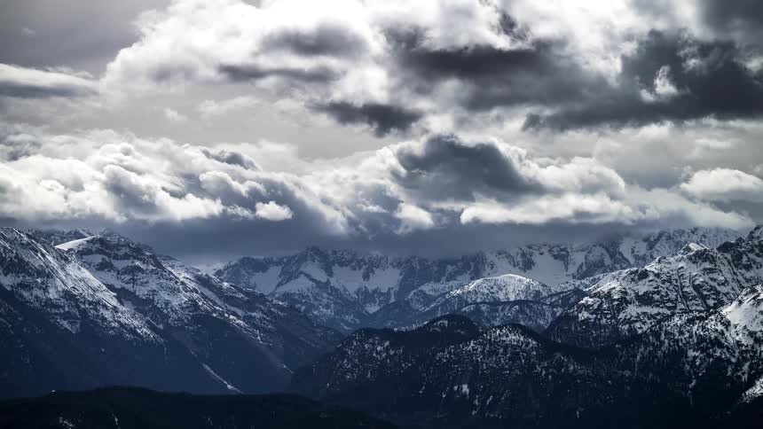 Clouds move in front of a mountain range