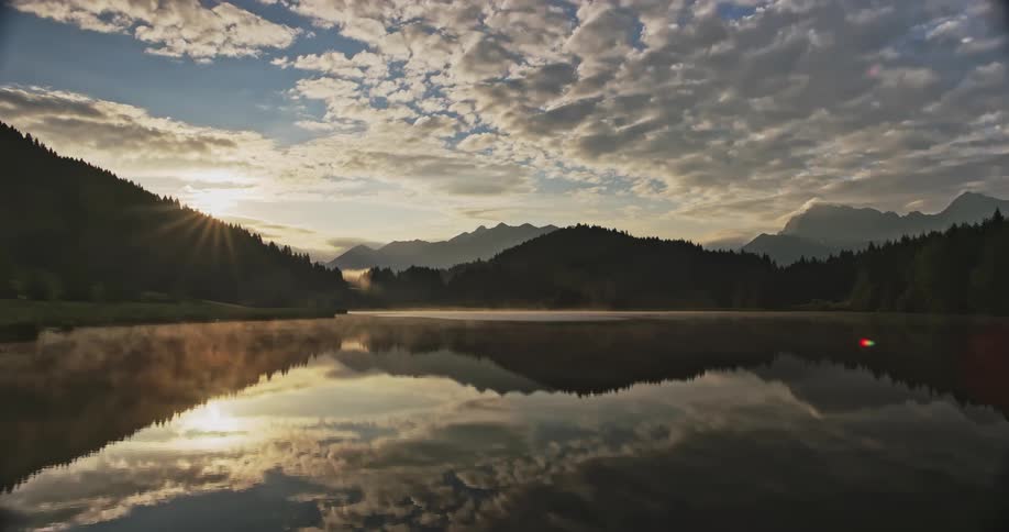 The mountains are covered with trees by the lake