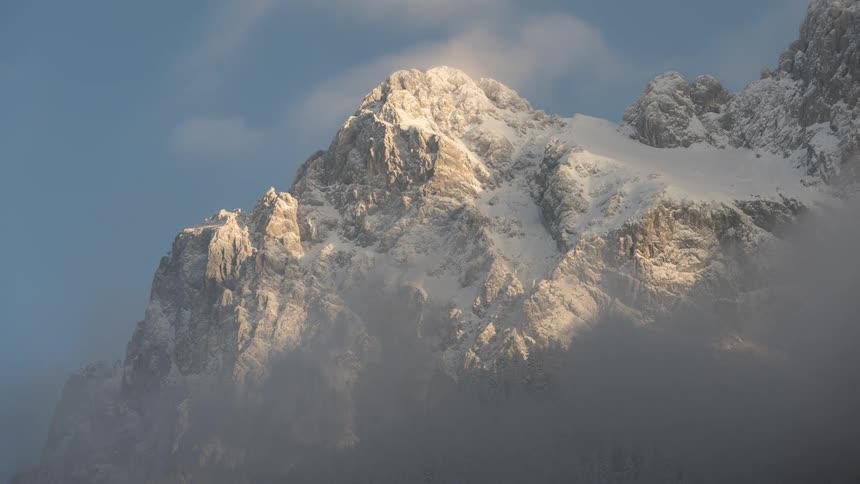 The clouds roll over the mountain peaks