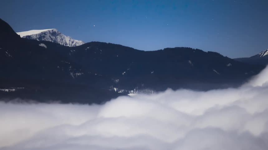 Airplanes fly over a mountain range and a swirling mass of clouds