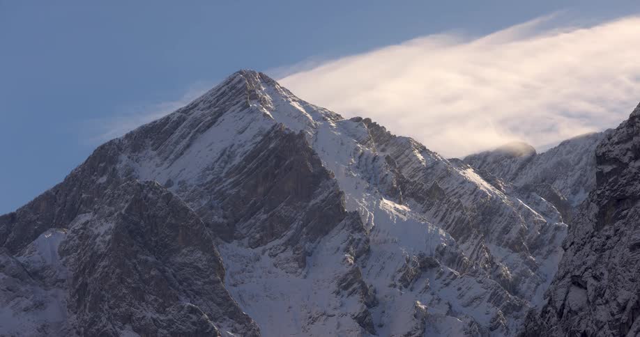 Time lapse of thin clouds rolling over a snowcovered mountain range