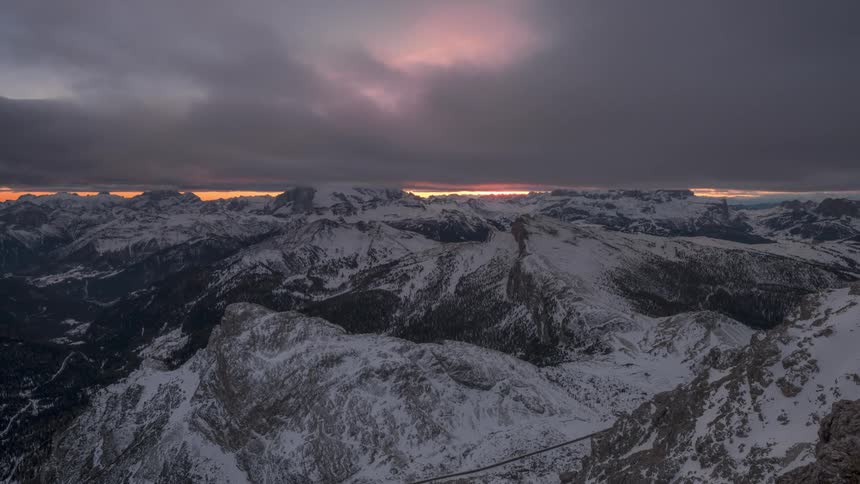 Time lapse of a thick layer of clouds rolling over the snowcovered slopes of a mountain range