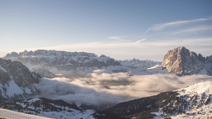 Time lapse of clouds nested on a valley between snowcovered mountains