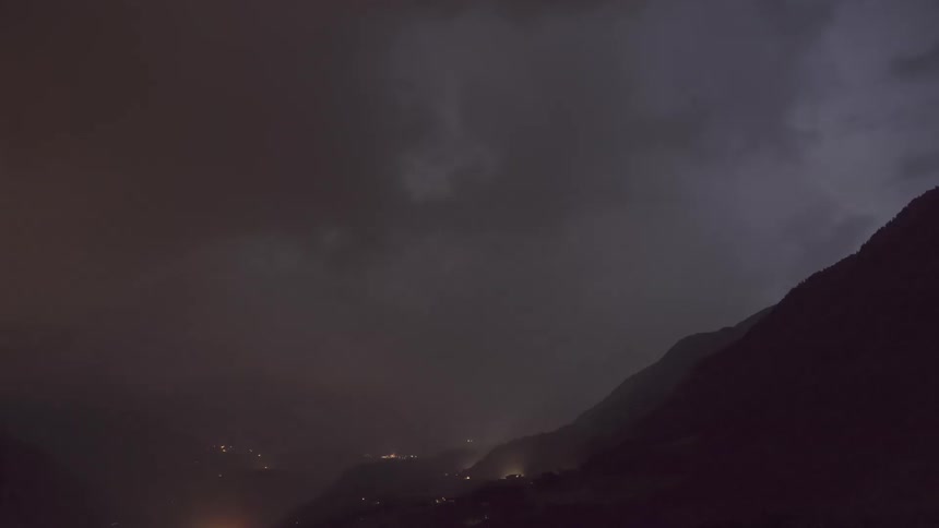 Silhouette of mountains at night and a sky with thunder