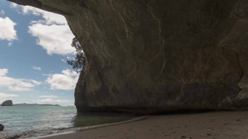Time lapse of a beach viewed from a natural cave next to the ocean