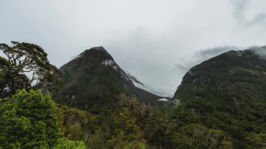 Time lapse of clouds rolling over green mountains in the jungle