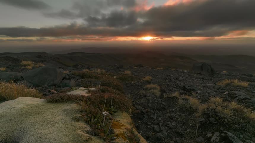 Time lapse orbital view of sunset over a rugged wilderness landscape