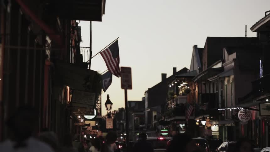 American flag flying on a small city downtown street  in the early evening