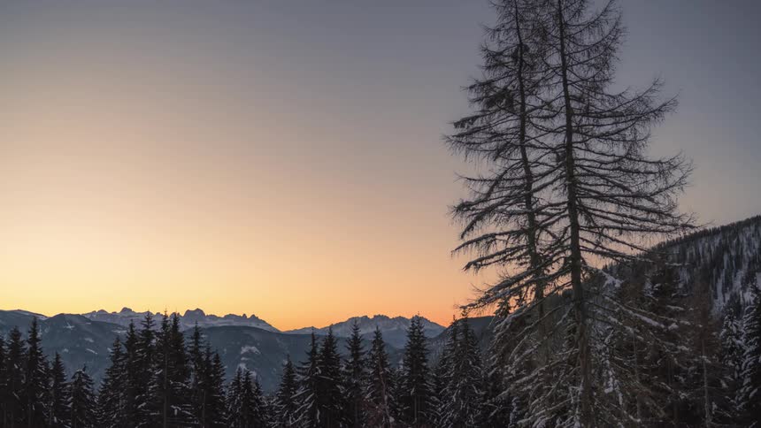 Time lapse of night and sunrise over a mountainous landscape