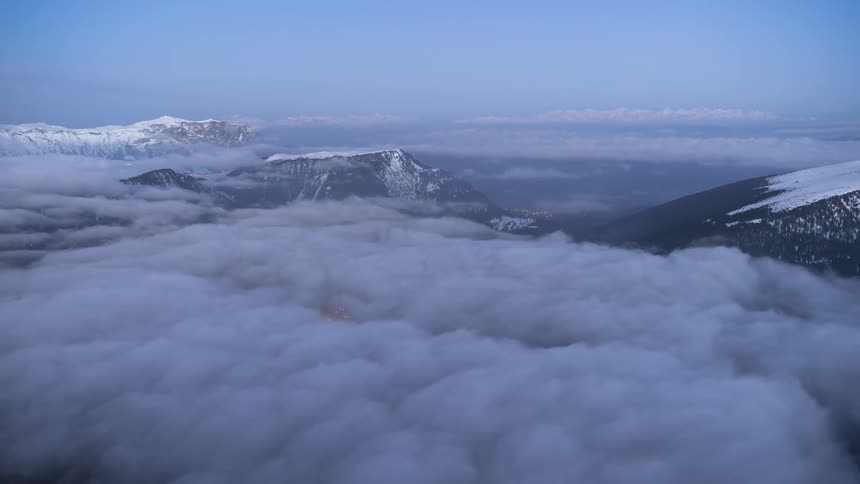 Time lapse of thin clouds rolling over a snowcovered mountain range