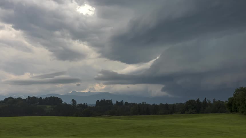 Storm clouds move over a grassland on a summer day