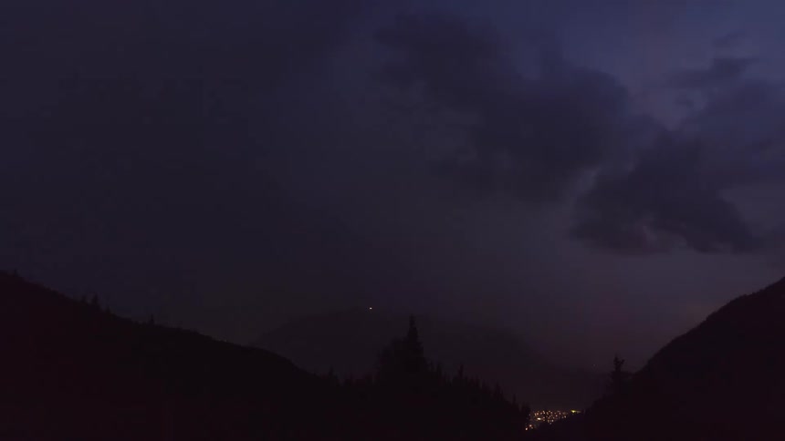 Silhouette of mountains with a dusk day and hazy clouds with thunder
