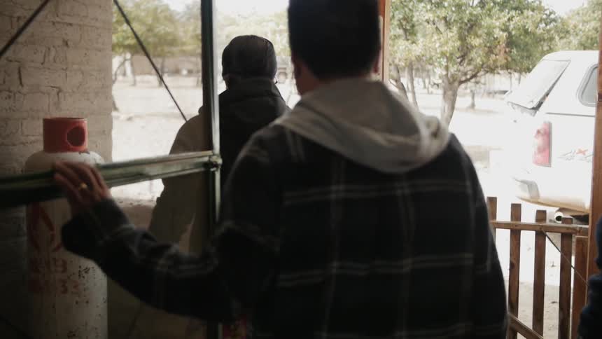 A man, woman and child walk outside to a snow covered yard