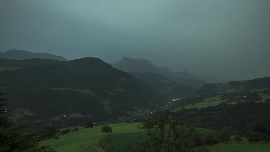 Panorama of mountains with a highway with vehicle traffic and a sky with thunder