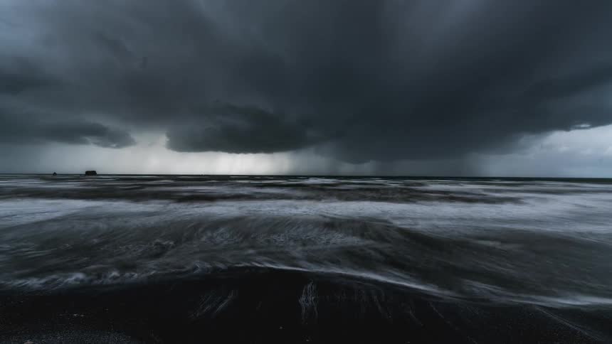 Time lapse of a dramatic seascape with dark storm clouds over a turbulent coastline
