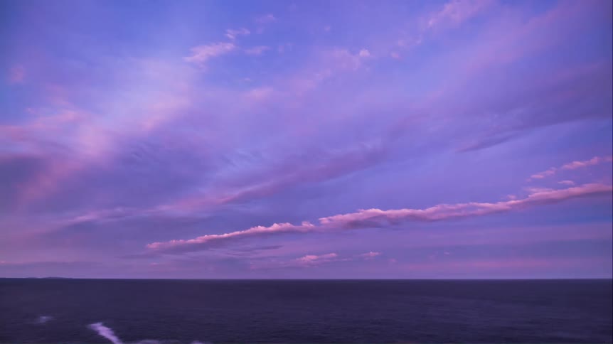 Vast blue sky with purple sky dawning above the sea