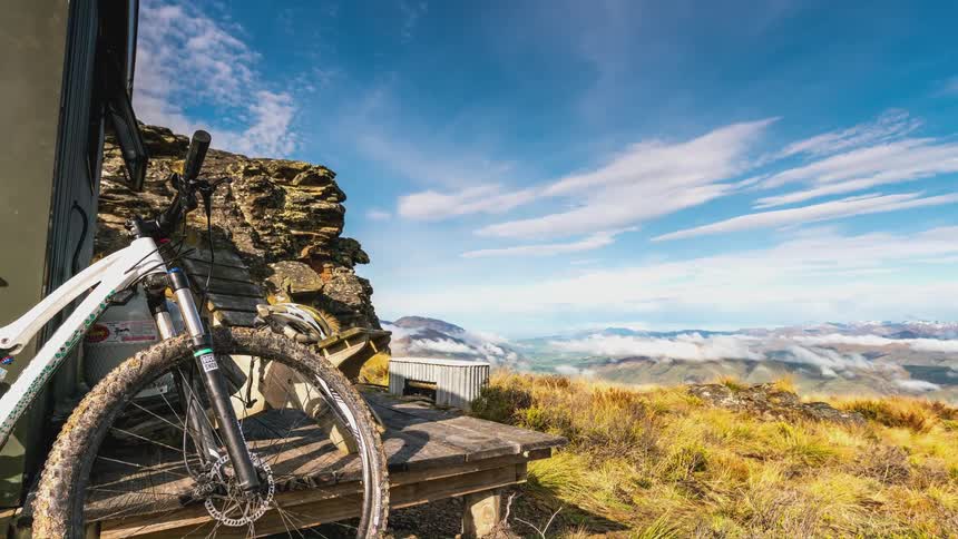 Mountain biking next to a wooden deck with natural views of the mountains